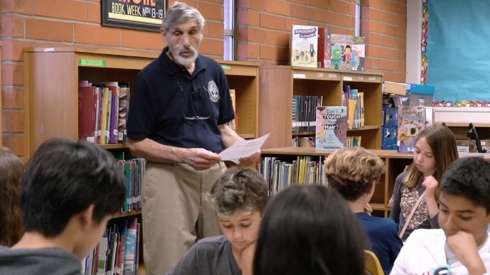 Photo
              of Jason Frand teaching a group of kids in a classroom